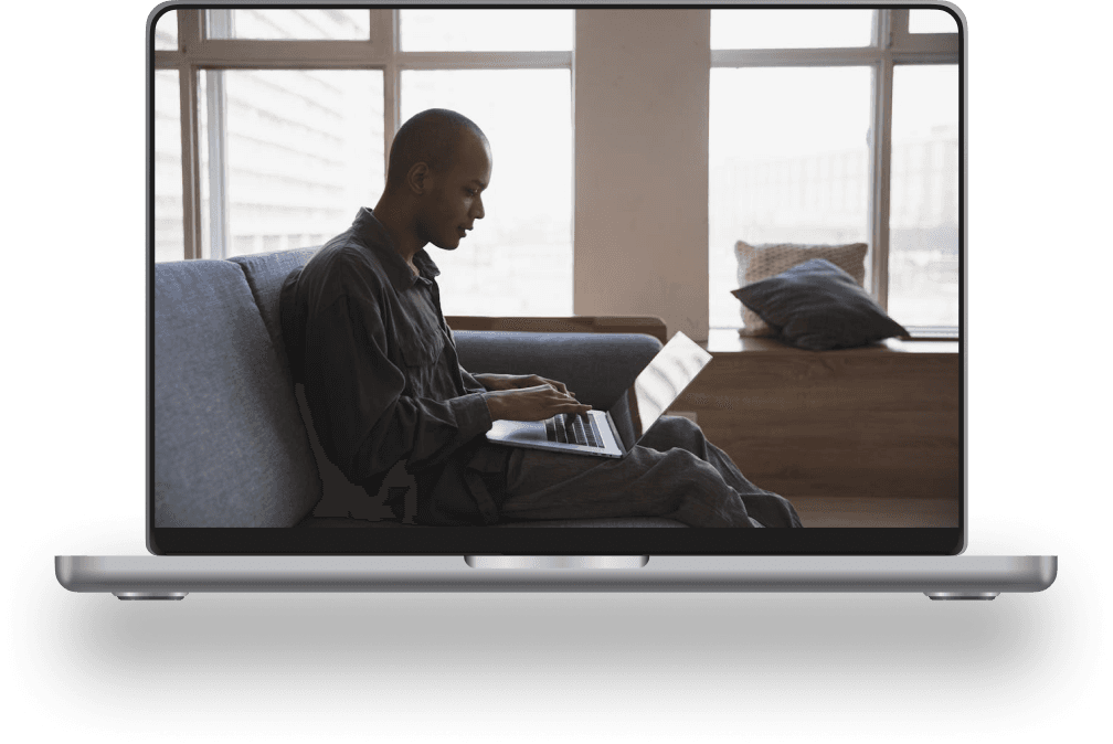 A person earning online, working on a laptop from their couch